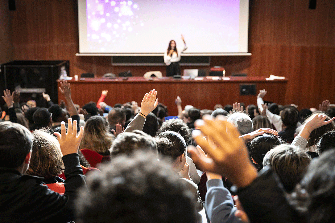 Public levant la main sur la conférence de Malika Arnaud