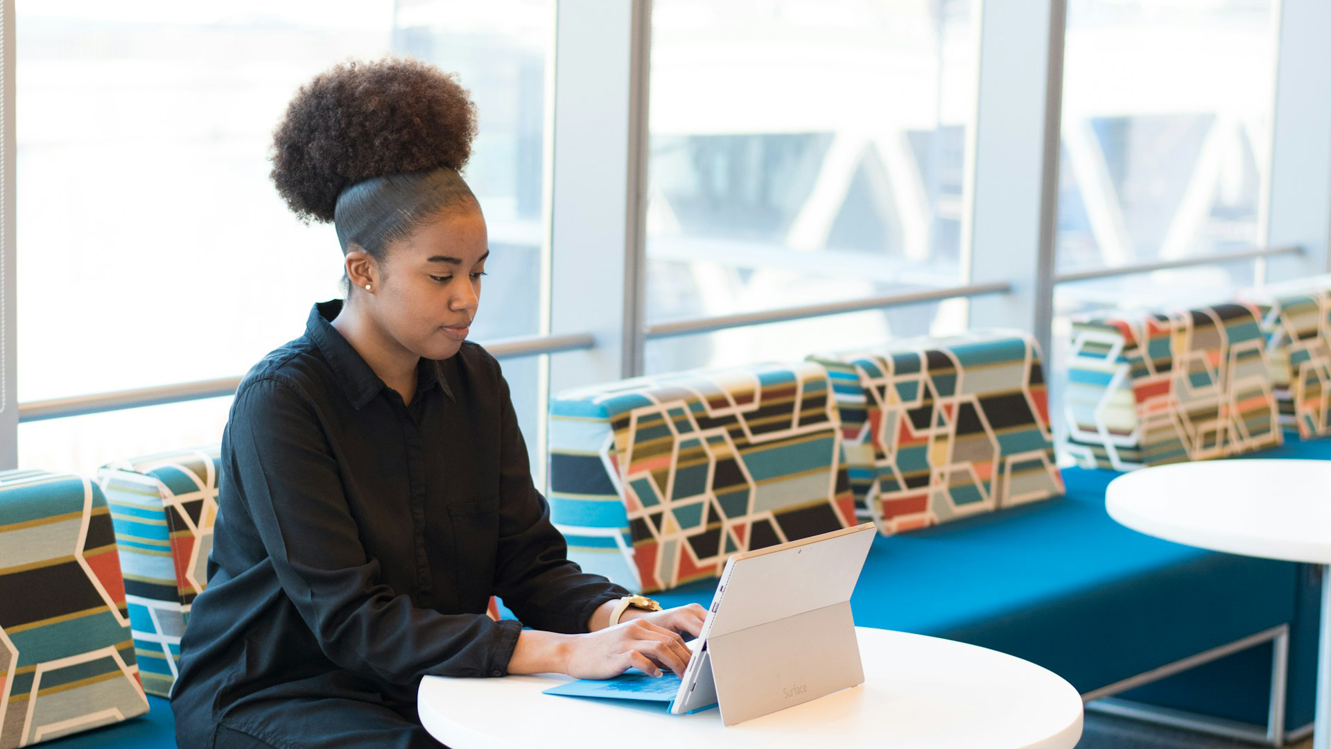 femme s’assoit sur le canapé tout en utilisant un ordinateur portable