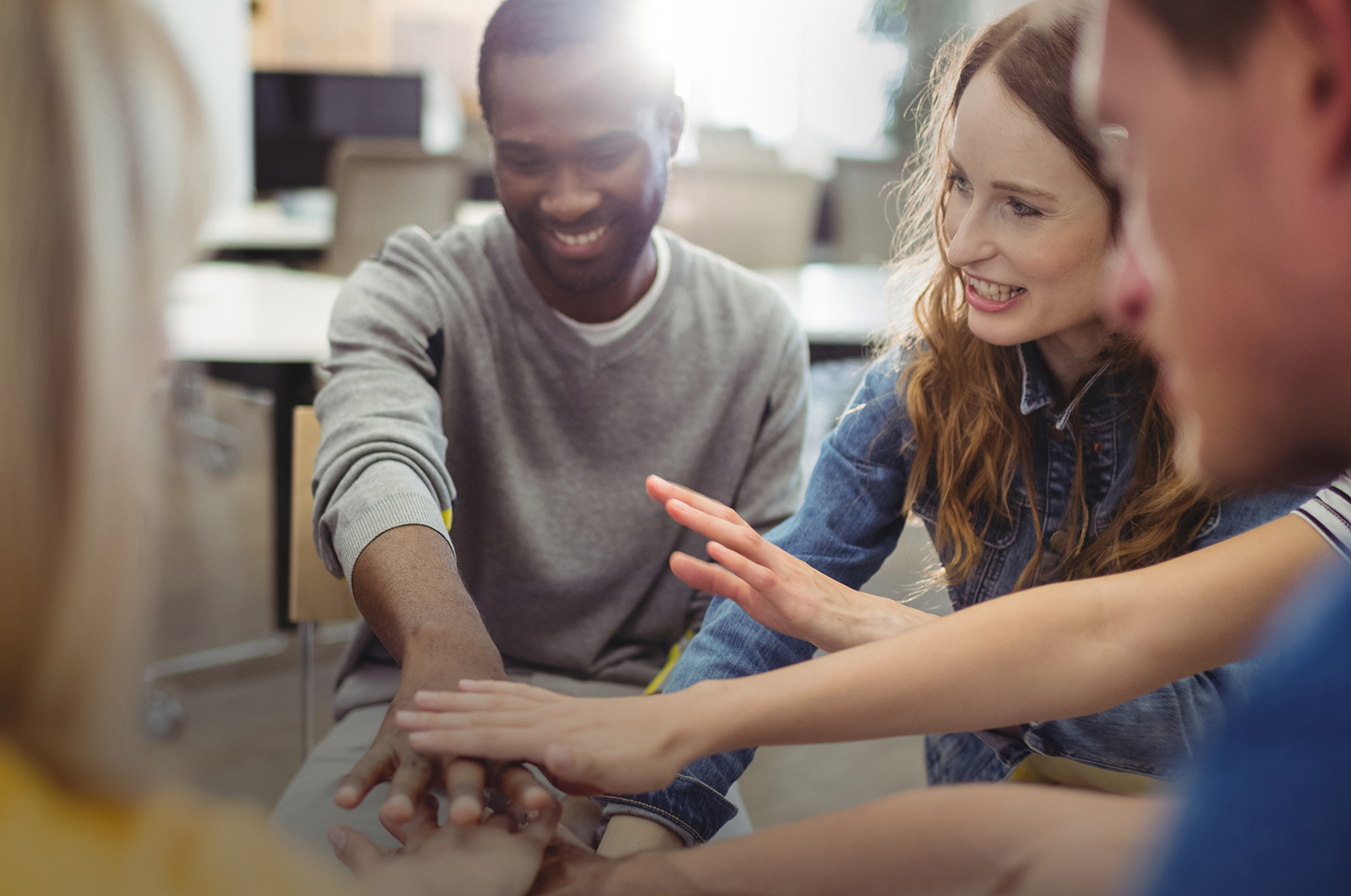 Des femmes et hommes se joignent les mains 